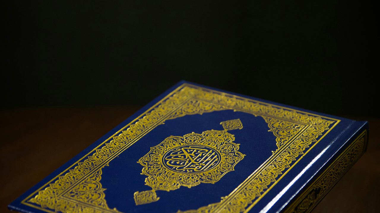 A copy of the Quran resting on a dark surface