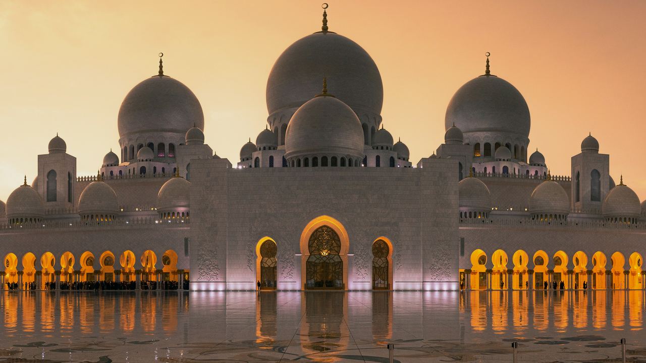A grand mosque beneath a golden dawn sky